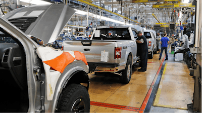In this Sept. 27, 2018, file photo a United Auto Workers assemblymen work on a 2018 Ford F-150 trucks being assembled at the Ford Rouge assembly plant in Dearborn, Mich.