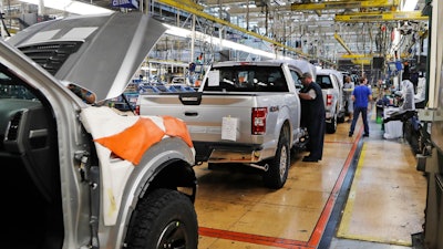 In this Sept. 27, 2018, file photo a United Auto Workers assemblymen work on a 2018 Ford F-150 trucks being assembled at the Ford Rouge assembly plant in Dearborn, Mich. The United Auto Workers union wants Detroit's three automakers to shut down their factories for two weeks to keep its members safe from the spreading coronavirus. But union President Rory Gamble says in an email to members obtained by The Associated Press that the companies were not willing to shut factories down.