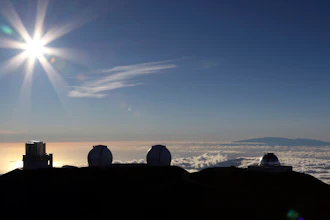 In this July 14, 2019, file photo, the sun sets behind telescopes at the summit of Mauna Kea in Hawaii. The cost to build a giant telescope that's unpopular among many Native Hawaiians is now estimated to have ballooned by a billion dollars. 'While an exact updated project cost will depend on when and where on-site construction begins for the Thirty Meter Telescope, the latest estimate for the TMT project is in the range of $2.4 billion in 2020 dollars,' Gordon Squires, TMT vice president, said in a statement this week. Construction of one of the world's largest telescopes on Hawaii's tallest mountain, Mauna Kea, has been stalled by foes of the embattled project who say the telescope will desecrate land held sacred to some Native Hawaiians.