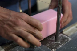In this photo taken Monday March 16 2020, a factory worker cuts soap into bars at the Licorne soap factory in Marseille, southern France. Amid the rapid outbreak of the new coronavirus across Europe, the hallmark Marseille tradition of soap-making is enjoying a renaissance, as the French public rediscovers this essential local product. As French shops were ordered closed this week in a bid to counter the new coronavirus, Bruna's Savonnerie de la Licorne now runs its operations only for delivery, supplying pharmacies across France and handling individual orders placed through its online store.