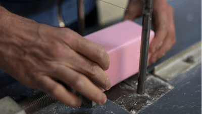 In this photo taken Monday March 16 2020, a factory worker cuts soap into bars at the Licorne soap factory in Marseille, southern France. Amid the rapid outbreak of the new coronavirus across Europe, the hallmark Marseille tradition of soap-making is enjoying a renaissance, as the French public rediscovers this essential local product. As French shops were ordered closed this week in a bid to counter the new coronavirus, Bruna's Savonnerie de la Licorne now runs its operations only for delivery, supplying pharmacies across France and handling individual orders placed through its online store.