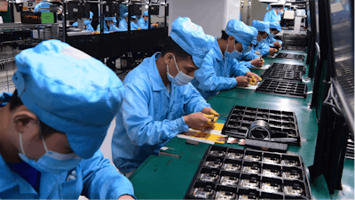 In this Feb. 13, 2020, photo released by Xinhua News Agency, workers wearing masks labor at a factory for Chinese telecommunications company OPPO in Dongguan, in southern China's Guangdong Province.
