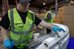 A worker guides toilet paper on a conveyor belt at the Tissue Plus factory, Wednesday, March 18, 2020, in Bangor, Maine. The new company has been unexpectedly busy because of the shortage of toilet paper brought on by hoarders concerned about the coronavirus.