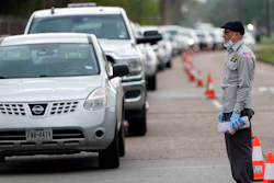 A man tries to talk to officials while standing in front of a line of cars stretching over two-miles to enter drive-thru testing for COVID-19 at United Memorial Medical Center, Thursday, March 19, 2020, in Houston. For most people, the coronavirus causes only mild or moderate symptoms, such as fever and cough. For some, especially older adults and people with existing health problems, it can cause more severe illness, including pneumonia.