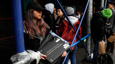 Anna Louisa, 18, receives a laptop for home study at the Lower East Side Preparatory School in New York, March 19, 2020.
