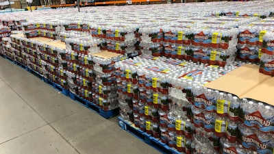 Cases of water sit in a Costco warehouse store as shoppers snap up bottled water in response to the coronavirus outbreak Thursday, March 19, 2020, in Sheridan, Colo.