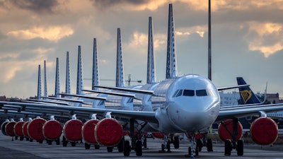 Vueling Airlines planes sit parked in a line at the Seville, Spain airport on Saturday, March 21, 2020, idled due to the COVID-19 coronavirus outbreak.