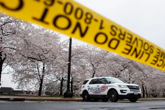 A Washington D.C. Metropolitan Police vehicle is parked on the other side of a tape police line along the Tidal Basin as cherry blossoms cover the trees, in Washington, Monday, March 23, 2020. As Washington, D.C. continues to work to mitigate the spread of the coronavirus (COVID-19), Mayor Muriel Bowser extended road closures and other measures to restrict access to the Tidal Basin, a main tourist attraction.