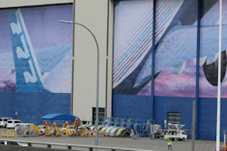 A worker walks near a mural of a Boeing 777 airplane at the company's manufacturing facility in Everett, Wash., March 23, 2020.