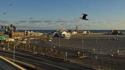 Light traffic and a mostly empty parking lot is seen along Pacific Coast Highway at the Santa Monica Pier, Monday, March 23, 2020, in Santa Monica, Calif.