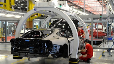 In this Wednesday, May 8, 2013 file photo, a technician works at the Ferrari department factory in Maranello, Italy.