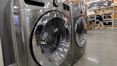 In this Jan. 27, 2020 file photo a clothes washer, left, and dryer, center, are on display at a Home Depot store location, in Boston. Orders to U.S. factories for big-ticket manufactured goods rose by a solid amount in February 2020, but the gain came before the coronavirus had shut down much of the country. The Commerce Department said Wednesday, March 25, durable goods orders rose 1.2% last month, rebounding from January when orders had shown a tiny 0.1% gain.