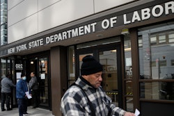 In this March 18, 2020 file photo, visitors to the Department of Labor are turned away at the door by personnel due to closures over coronavirus concerns in New York.