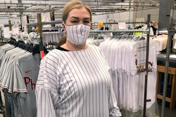 This image provided by Fanatics, shows a model wearing a protective mask and gown for medical professionals made from the fabric of a baseball uniform.