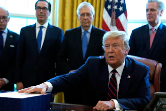 President Donald Trump speaks before he signs the coronavirus stimulus relief package in the Oval Office at the White House, Friday, March 27, 2020, in Washington. Listening are from left, Larry Kudlow, White House chief economic adviser, Treasury Secretary Steven Mnuchin, Senate Majority Leader Mitch McConnell, R-Ky., and House Minority Leader Kevin McCarty of Calif.
