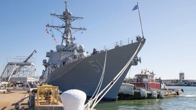 A tug boat pulls along side the guided missile destroyer USS Arleigh Burke (DDG 51) as the ship prepares to get underway for sea trials in January.