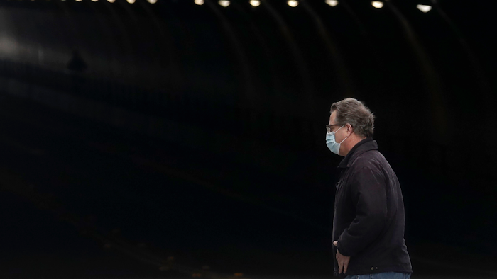 A man wears a mask while crossing in front of the Stockton Street Tunnel in San Francisco, Sunday, March 29, 2020.