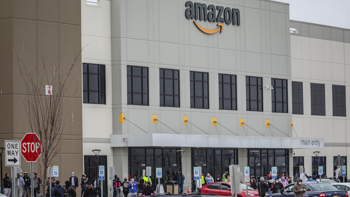 In this March 30, 2020 file photo, workers at Amazon's fulfillment center in Staten Island, N.Y., gather outside to protest work conditions in the company's warehouse in New York. Amazon fired a worker who staged the walkout to demand greater protection against the new coronavirus, saying the employee himself flaunted distancing rules and put others at risk. The decision prompted a rebuke from New York Attorney General Letitia James, who called on the National Labor Relations Board to investigate.