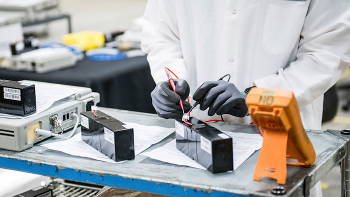 In this March 28, 2020, file photo, David Yee, an NPI mechanical engineer, tests voltage of new batteries at Bloom Energy in Sunnyvale, Calif. The COVID-19 outbreak has prompted companies large and small to rethink how they do business. Bloom Energy makes hydrogen fuel cells. But recently, they have been refurbishing old ventilators so hospitals can use them to keep coronavirus patients alive.