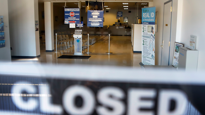 In this April 3, 2020, file photo, the seats and aisles are empty as seen through the window of the closed Penndot Drivers License Center in Butler, Pa.