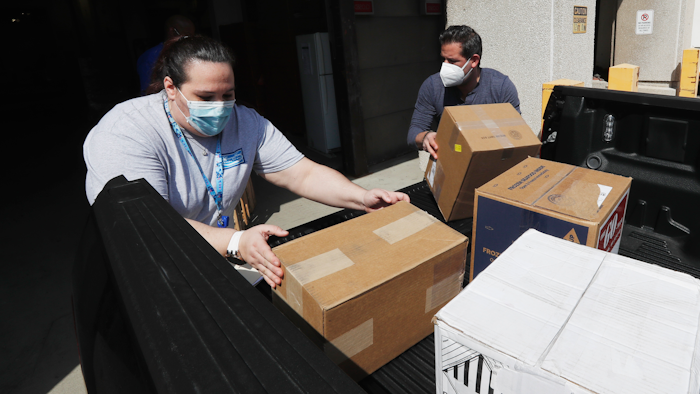 Christina Caldwell, left, of Henry Ford Population Health helps unload supplies with Matt Thatcher, who donated them from the Detroit Golf Club, Wednesday, April 8, 2020, in Detroit. The hospital is also in need of gowns and other PPE items and hopes more donations will be coming in from others to help during the coronavirus pandemic.