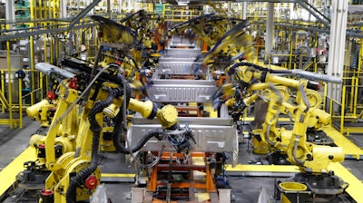 In this Sept. 27, 2018, file photo robots weld the bed of a 2018 Ford F-150 truck on the assembly line at the Ford Rouge assembly plant in Dearborn, Mich.