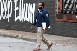 In this March 31, 2020, file photo, City of Dallas code compliance officer Eldho Babu checks on businesses amid concerns of COVID-19 spreading in the Deep Ellum section of Dallas. Resident snitches are emerging as enthusiastic allies as cities, states and countries work to enforce directives meant to limit person-to-person contact amid the virus pandemic that already has claimed tens of thousands of lives worldwide.