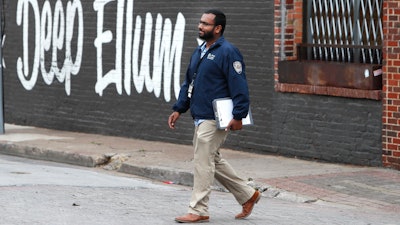 In this March 31, 2020, file photo, City of Dallas code compliance officer Eldho Babu checks on businesses amid concerns of COVID-19 spreading in the Deep Ellum section of Dallas. Resident snitches are emerging as enthusiastic allies as cities, states and countries work to enforce directives meant to limit person-to-person contact amid the virus pandemic that already has claimed tens of thousands of lives worldwide.