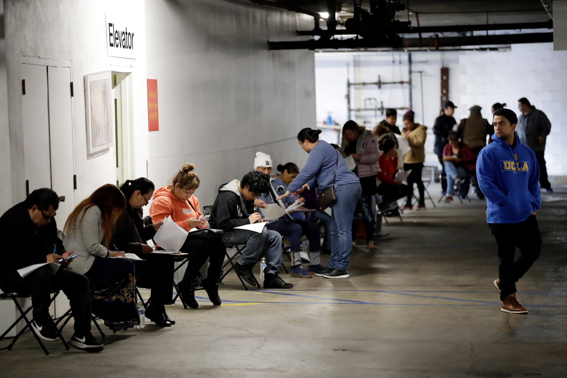 In this March 13, 2020 file photo, unionized hospitality workers wait in line in a basement garage to apply for unemployment benefits at the Hospitality Training Academy in Los Angeles. More than 6.6 million Americans applied for unemployment benefits last week, far exceeding a record high set just last week, a sign that layoffs are accelerating in the midst of the coronavirus.