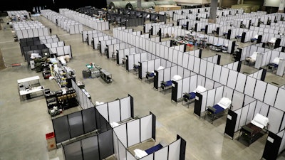 Rows of patient beds are shown at a military field hospital, Sunday, April 5, 2020, at the CenturyLink Field Event Center in Seattle. Officials said the facility, which will be used for people with medical issues that are not related to the new coronavirus outbreak, has more than 200 beds and is ready now to receive patients.