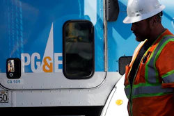 In this Aug. 15, 2019, file photo, a Pacific Gas & Electric worker walks in front of a truck in San Francisco.