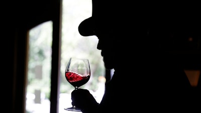 In this photo taken Wednesday, April 1, 2020, George Webber, dressed as 'The Count' Agoston Haraszthy, swirls a glass of Moon Mountain Cabernet Sauvignon during a virtual online tasting and tour of the historic Buena Vista Winery in Sonoma, Calif. The winery is the state's oldest commercial winery dating to 1857. Wineries that want to stay viable and connected to their customers during the coronavirus pandemic are harnessing platforms such as Facebook Live to offer virtual wine experiences.