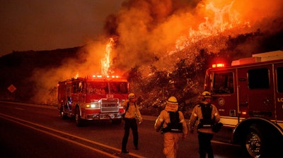 In this Nov. 26, 2019, file photo, firefighters battle the Cave Fire as it flares up along Highway 154 in the Los Padres National Forest above Santa Barbara, Calif.