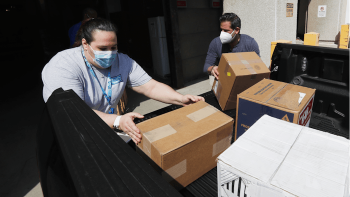 Christina Caldwell, left, of Henry Ford Population Health helps unload supplies with Matt Thatcher, who donated them from the Detroit Golf Club, Wednesday, April 8, 2020, in Detroit. The hospital is also in need of gowns and other PPE items and hopes more donations will be coming in from others to help during the coronavirus pandemic.