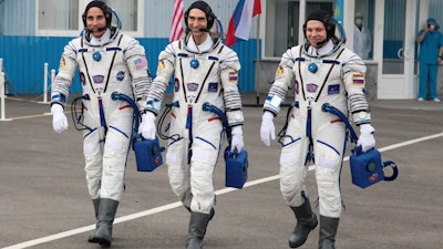 In this handout photo released by Roscosmos Space Agency Press Service U.S. astronaut Chris Cassidy, left, Russian cosmonauts Anatoly Ivanishin, centre, and Ivan Vagner, members of the main crew of the expedition to the International Space Station (ISS), walk prior the launch of Soyuz MS-16 space ship at the Russian leased Baikonur cosmodrome, Kazakhstan, Thursday, April 9, 2020.