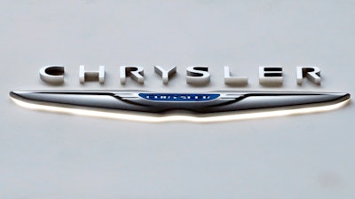This Feb. 14, 2019 photo shows the Chrysler logo at the 2019 Pittsburgh International Auto Show in Pittsburgh. Fiat Chrysler is recalling more than 550,000 vehicles worldwide, Tuesday, April 14, 2020, because the windshield wiper arms can come loose and stop the wipers from working properly. The recall covers certain 2019 and 2020 Ram 1500, 1500 Classic pickups and Jeep Compass SUVs.