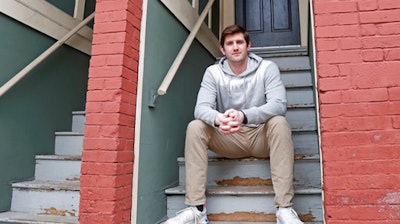 Cameron Karosis, 27, a software salesman, poses for a portrait outside his home, Tuesday, April 14, 2020, in Cambridge, Mass.