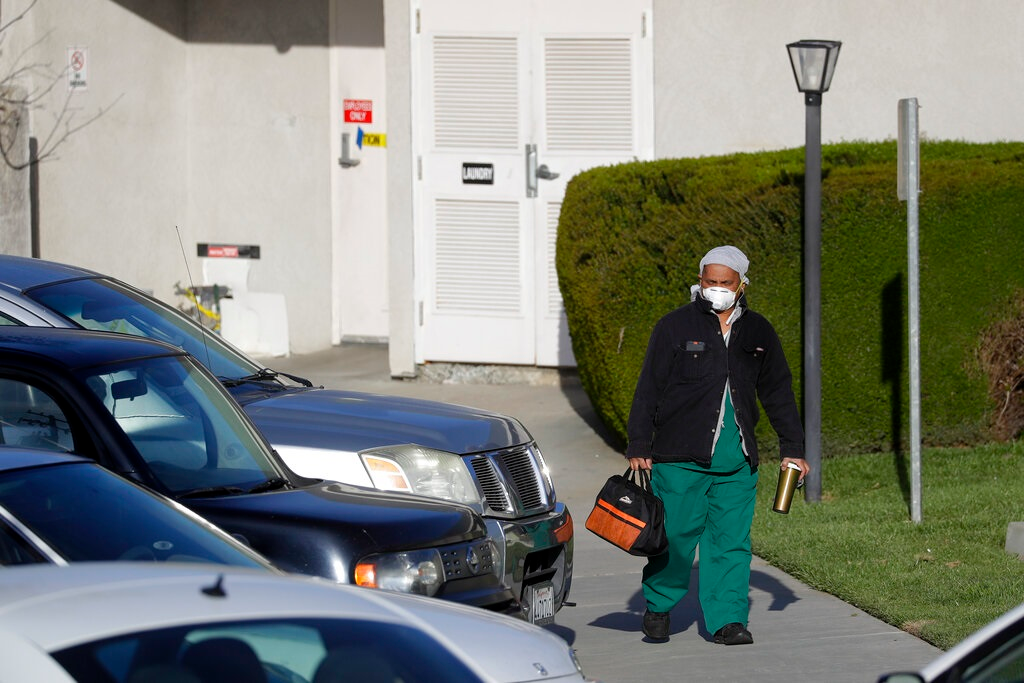 A health care worker leaves Cedar Mountain Post Acute nursing facility in Yucaipa, Calif., Wednesday, April 1, 2020. The Southern California nursing home has been hit hard by the coronavirus, with more than 50 residents infected, a troubling development amid cautious optimism that cases in the state may peak more slowly than expected.