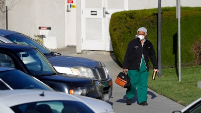 A health care worker leaves Cedar Mountain Post Acute nursing facility in Yucaipa, Calif., Wednesday, April 1, 2020. The Southern California nursing home has been hit hard by the coronavirus, with more than 50 residents infected, a troubling development amid cautious optimism that cases in the state may peak more slowly than expected.