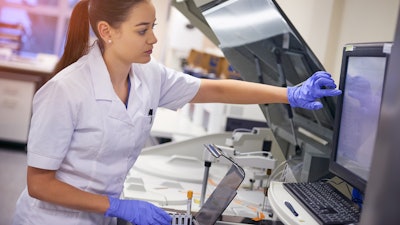 A lab technician using HMI to analyze blood samples.