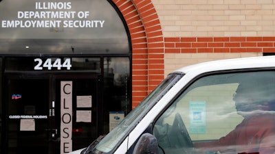 A man looks at the closed sign in front of Illinois Department of Employment Security in Chicago, Wednesday, April 15, 2020. With half-a-million people bounced out of jobs in the past month because of the COVID-19 pandemic, Illinois' unemployment safety net has been stretched to the limit.