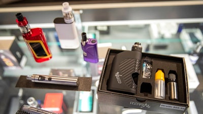 In this Thursday, Jan. 2, 2020 file photo, vaping devices are displayed at a store in New York. On Thursday, April 23, 2020, the U.S. Food and Drug Administration said that a federal court accepted its request to push back the May 12 deadline to submit vaping product applications to Sept. 9. The agency said the COVID-19 pandemic has delayed preparations to meet the deadline for both companies and FDA staff.