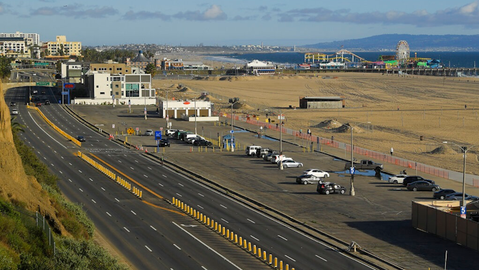 In this March 23, 2020 file photo, light traffic and a mostly empty parking lot is seen along Pacific Coast Highway, in Santa Monica, Calif. 2020. The U.S. government is estimating that traffic deaths fell 1.2% last year to 36,120. The National Highway Traffic Safety Administration says it’s the third year in a row that fatalities dropped.