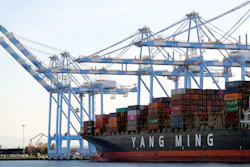 Cargo cranes take containers off a Yang Ming Marine boat at the Port of Tacoma, Tacoma, Wash., Nov. 4, 2019.