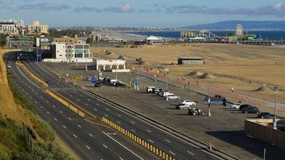 In this March 23, 2020 file photo, light traffic and a mostly empty parking lot is seen along Pacific Coast Highway, in Santa Monica, Calif. 2020. The U.S. government is estimating that traffic deaths fell 1.2% last year to 36,120. The National Highway Traffic Safety Administration says it’s the third year in a row that fatalities dropped.