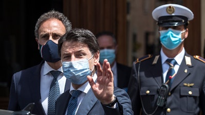 Italian Premier Giuseppe Conte waves after attending a session at the Senate in Rome, Wednesday, May 20, 2020.