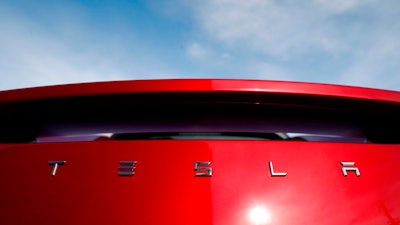 In this April 15, 2018 file photo, the sun shines off the rear deck of a roadster on a Tesla dealer's lot in the south Denver suburb of Littleton, Colo. Tesla has picked Austin, Texas, and Tulsa, Oklahoma, as finalists for its new U.S. assembly plant, a person briefed on the matter said Friday, May 15, 2020.