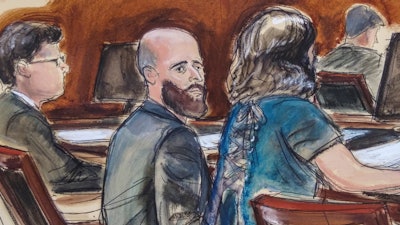 In this courtroom sketch, Joshua Schulte, center, is seated at the defense table flanked by his attorneys during jury deliberations, March 4, 2020, in New York.