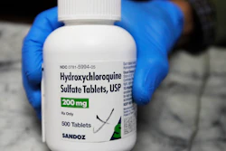 A pharmacist holds a bottle of hydroxychloroquine in Oakland, Calif., April 6, 2020.
