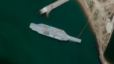 In this Sunday, June 7, 2020 satellite photo provided by Maxar Technologies, a fake aircraft carrier is seen off the coast of Bandar Abbas, Iran.
